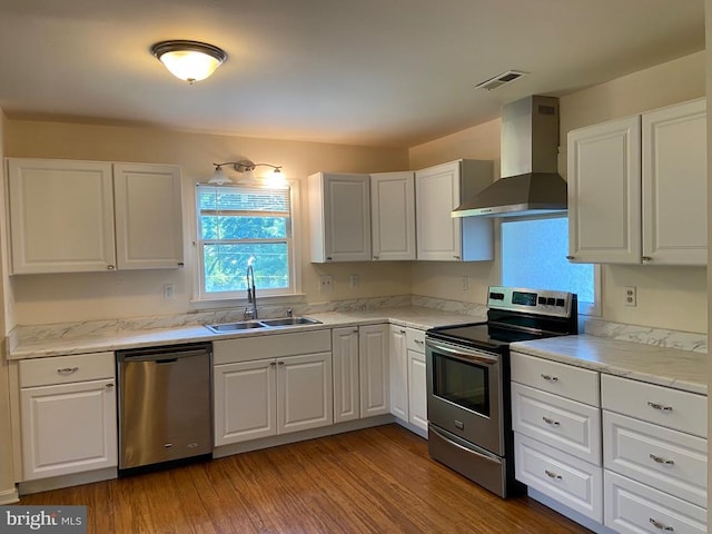 20 Calhoun St N, Warrenton, VA 20186 - kitchen with appliances with stainless steel finishes, wall chimney range hood, white cabinets, and light wood-type flooring