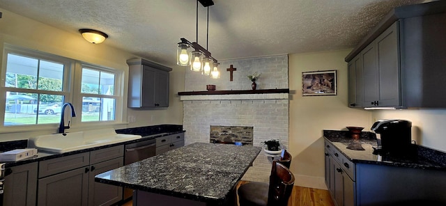 242 1st St, Broadway, VA 22815 - kitchen with a textured ceiling, wood finished floors, dark stone counters, a center island, and a fireplace