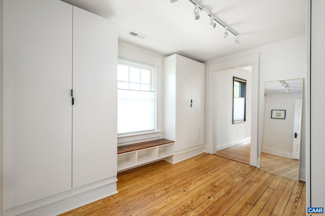 mudroom with rail lighting, light wood-type flooring, and baseboards