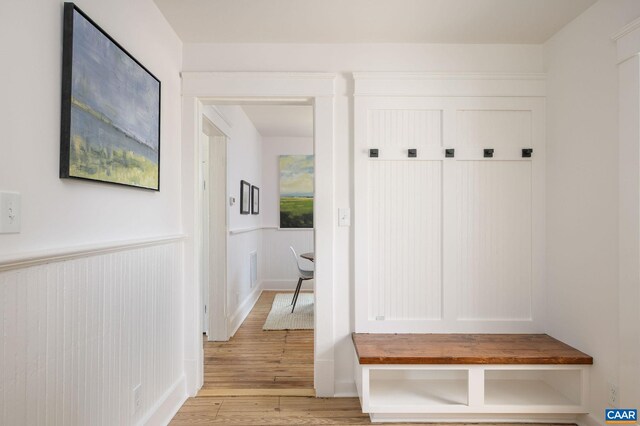 mudroom with light wood-style floors and wainscoting
