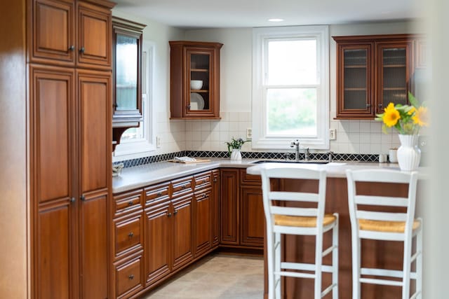 199 Hermitage Rd, Staunton, VA 24401 - kitchen with a sink, backsplash, glass insert cabinets, and brown cabinetry