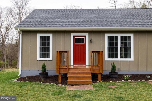 147 Fishermans Ln, Luray, VA 22835 - view of exterior entry with board and batten siding, a shingled roof, and a lawn