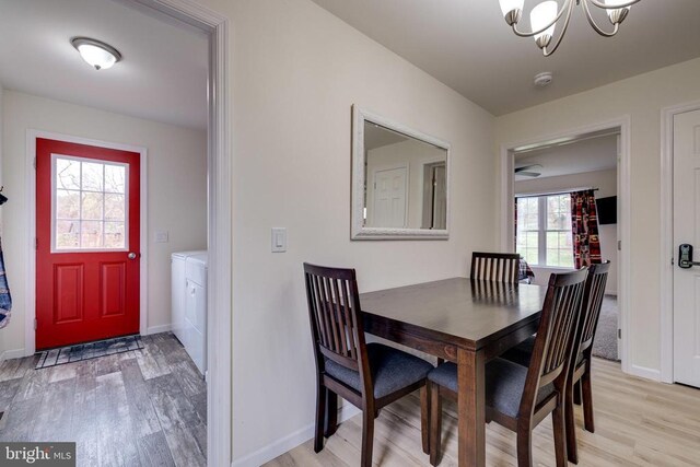 147 Fishermans Ln, Luray, VA 22835 - dining area with light wood-style flooring, washer / dryer, baseboards, and a chandelier