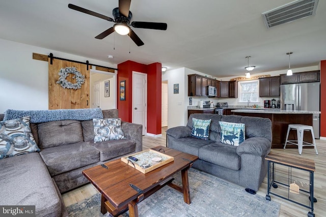 147 Fishermans Ln, Luray, VA 22835 - living area with light wood-style floors, a ceiling fan, and a barn door