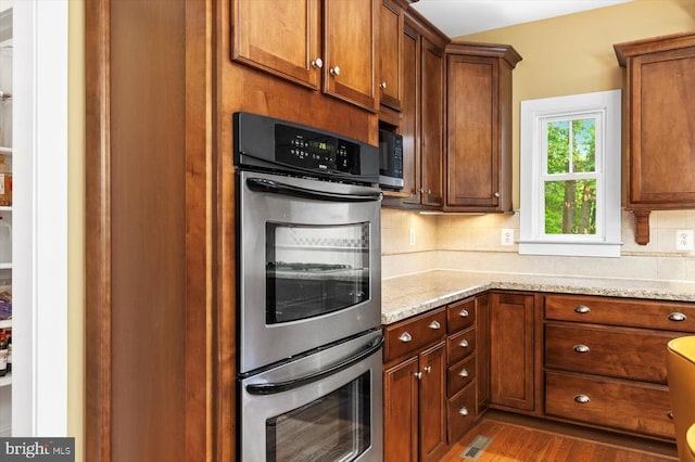 9937 Talley Rd, Spotsylvania, VA 22553 - kitchen with stainless steel double oven, backsplash, wood finished floors, and light stone countertops
