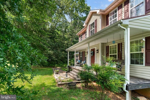  - view of side of property with a porch and a yard