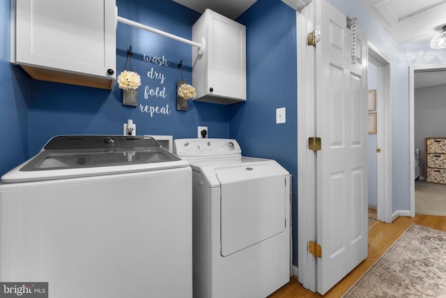  - laundry room featuring cabinet space, washer and dryer, light wood-type flooring, and attic access