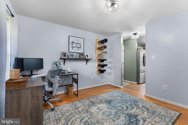  - office area featuring wood finished floors and baseboards
