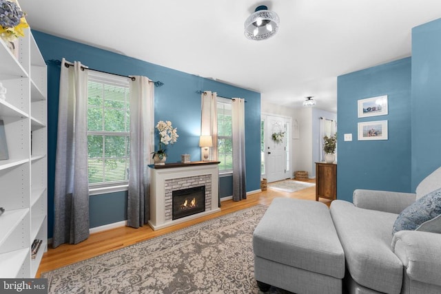  - living area featuring wood finished floors and a brick fireplace