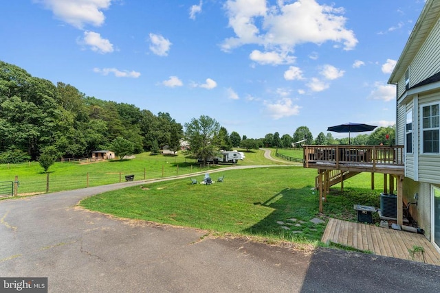  - view of yard featuring a deck and asphalt driveway
