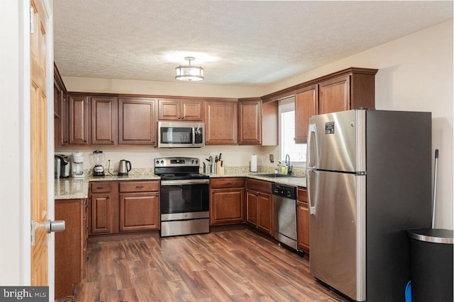 159 Park View Ln, Shenandoah, VA 22849 - kitchen featuring stainless steel appliances, dark wood-type flooring, light stone counters, brown cabinetry, and a textured ceiling
