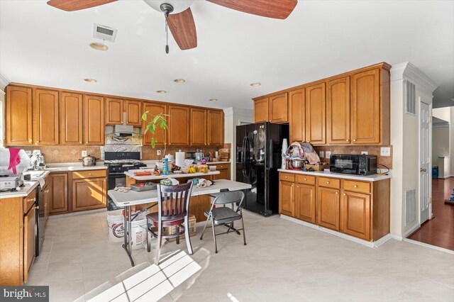 1745 Finley Dr, Culpeper, VA 22701 - kitchen with black appliances, under cabinet range hood, ceiling fan, decorative backsplash, and brown cabinetry