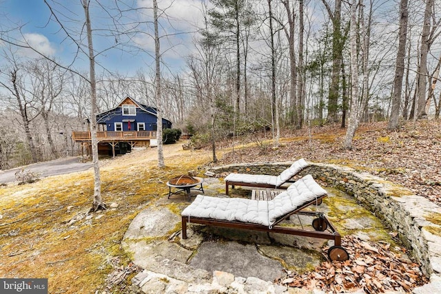 view of yard featuring a wooden deck and an outdoor fire pit