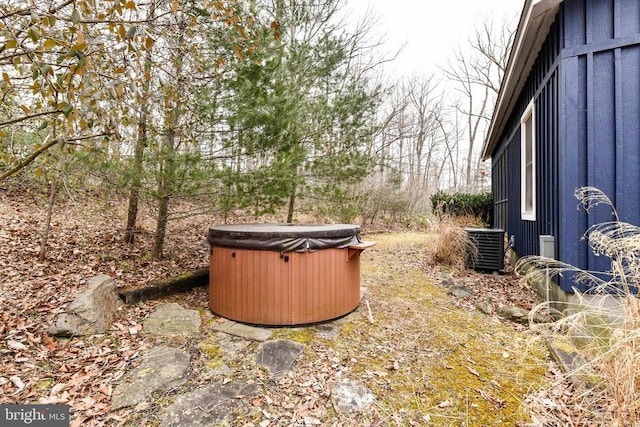 view of yard featuring a hot tub and central AC unit