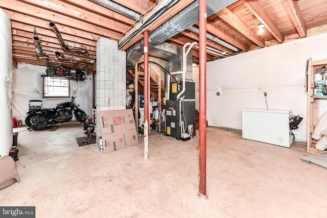 basement featuring heating unit and refrigerator