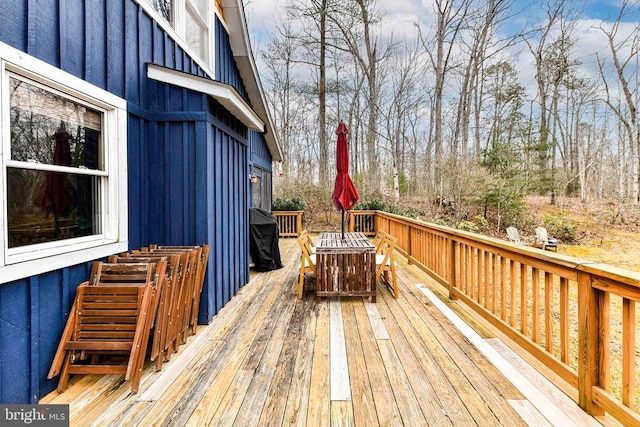 wooden terrace featuring area for grilling and an outdoor fire pit