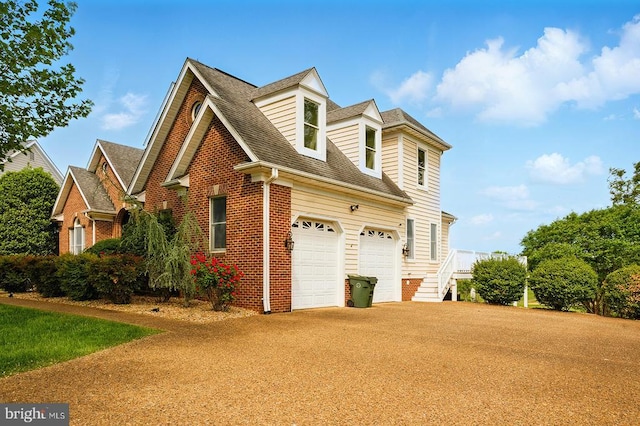 view of side of property with a shingled roof, brick siding, driveway, and a garage