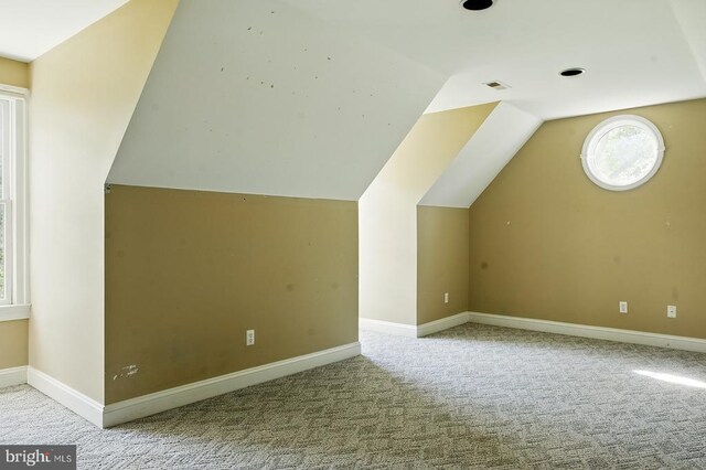 bonus room with baseboards, carpet flooring, visible vents, and vaulted ceiling