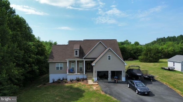 view of front of property with a porch, a garage, and a front lawn