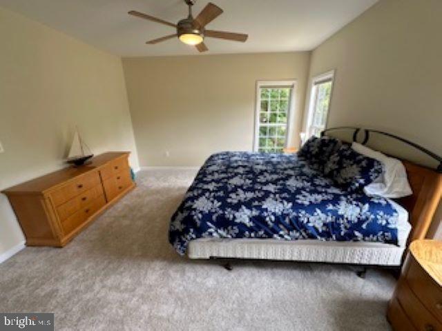 bedroom featuring light carpet and ceiling fan