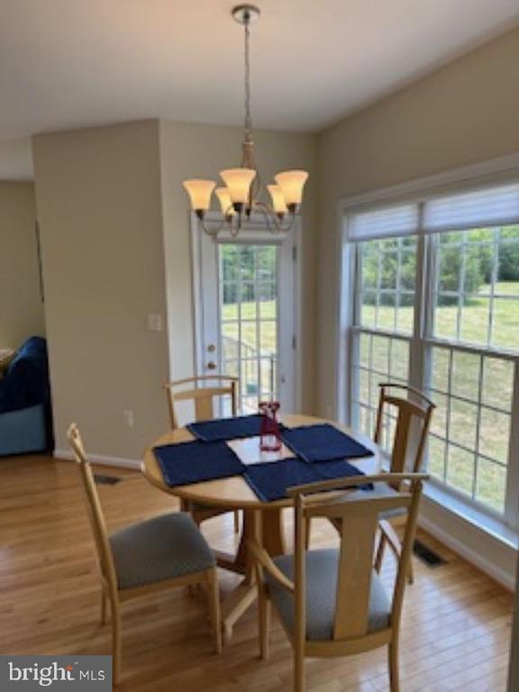 dining space with an inviting chandelier and light hardwood / wood-style flooring