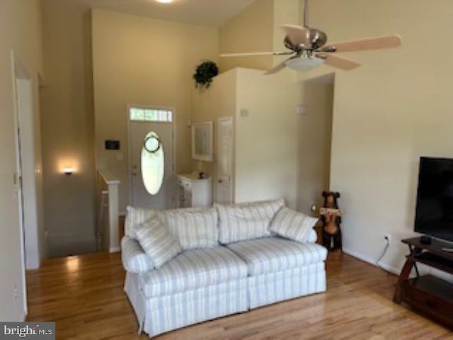 living room with light hardwood / wood-style flooring, high vaulted ceiling, and ceiling fan