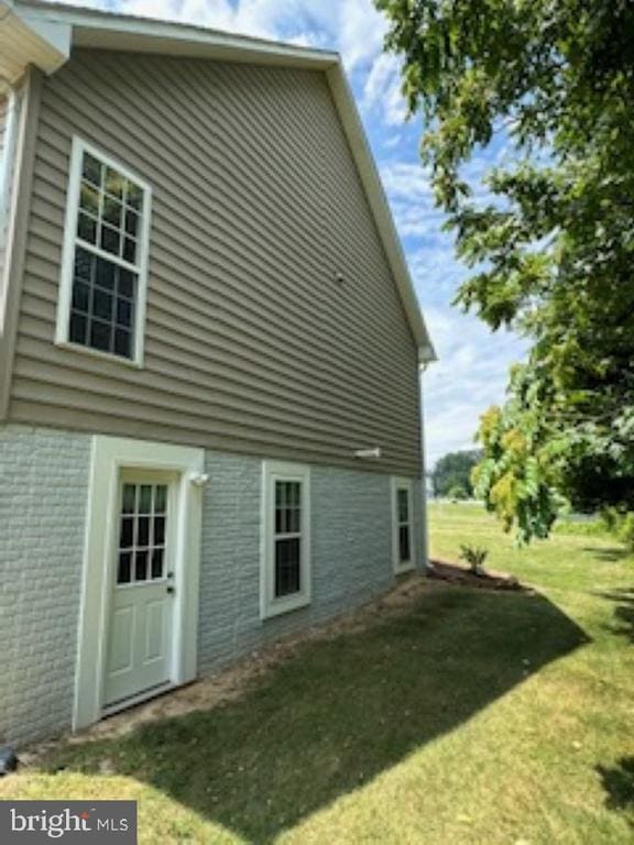 view of side of home with a yard