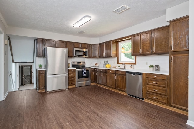 2822 Plantation Ln, Waynesboro, VA 22980 - kitchen featuring stainless steel appliances, light countertops, a sink, dark wood-style flooring, and backsplash