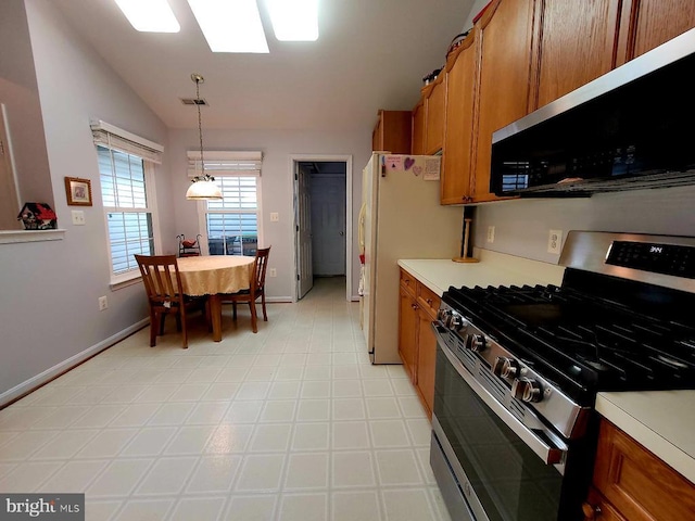 11611 Hampshire Ct, Fredericksburg, VA 22407 - kitchen with stainless steel gas range oven, brown cabinets, vaulted ceiling, light countertops, and baseboards