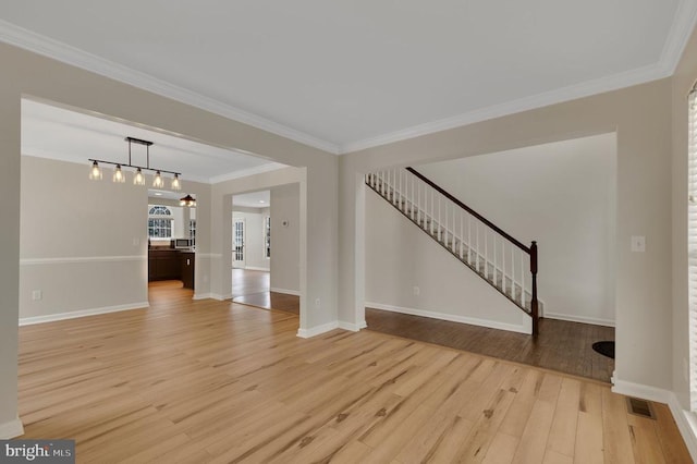 unfurnished living room featuring crown molding and light wood-type flooring