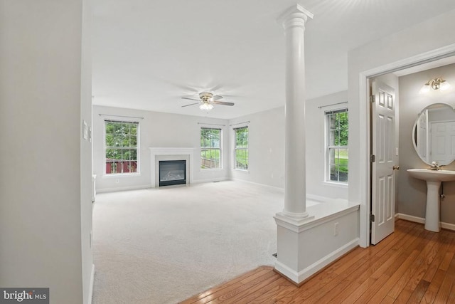 538 Colony Ct, Warrenton, VA 20186 - unfurnished living room featuring ornate columns, baseboards, a ceiling fan, a fireplace, and wood-type flooring