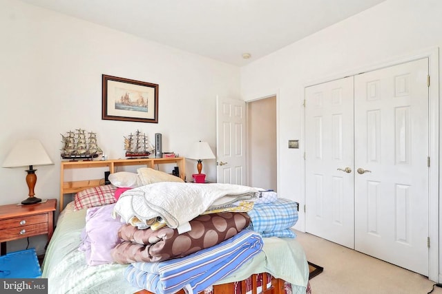 bedroom with light colored carpet and a closet
