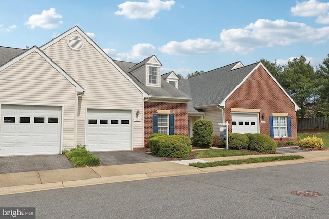 view of front facade with brick siding, asphalt driveway, a garage, and a shingled roof