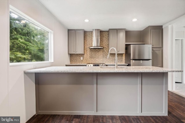 8708 Berkeley Farms Ln, Partlow, VA 22534 - kitchen with freestanding refrigerator, dark wood finished floors, gray cabinets, wall chimney range hood, and light stone counters