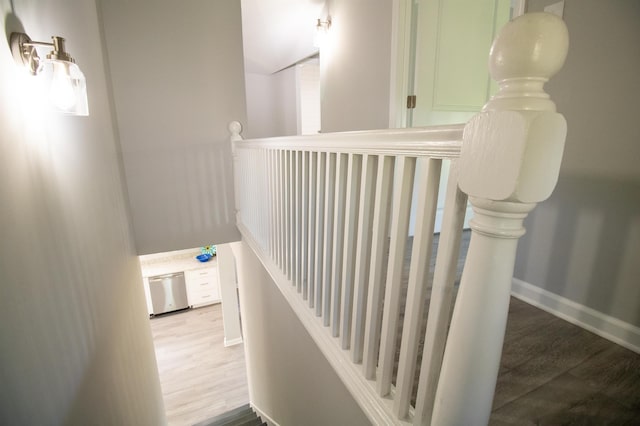 staircase with wood finished floors and baseboards