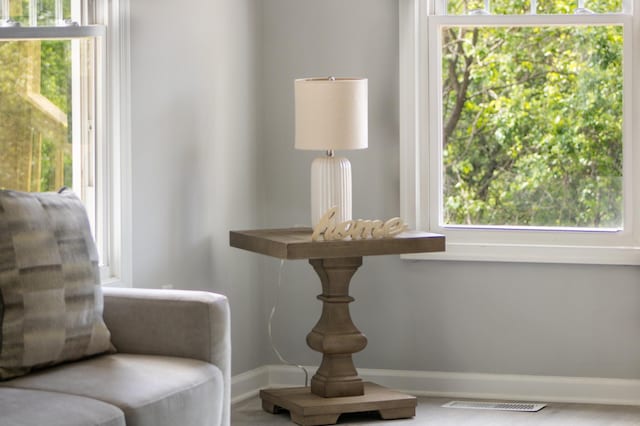 sitting room featuring baseboards and plenty of natural light