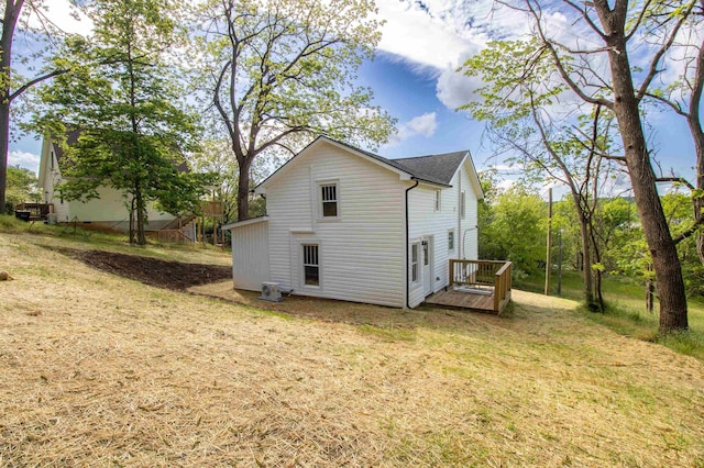rear view of property featuring a yard and a deck
