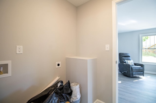 clothes washing area featuring electric dryer hookup, washer hookup, baseboards, and wood finished floors