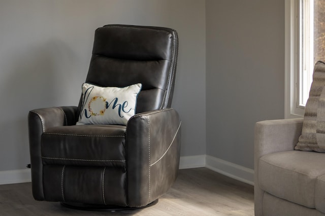 sitting room with baseboards and wood finished floors