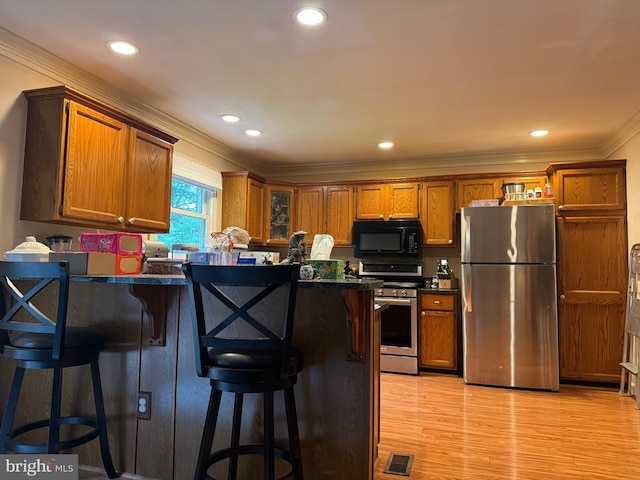 11068 Alum Springs Rd, Culpeper, VA 22701 - kitchen featuring stainless steel appliances, dark countertops, crown molding, a breakfast bar, and light wood-style floors