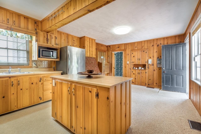 2860 Uphill Dr, Broadway, VA 22815 - kitchen with appliances with stainless steel finishes, light countertops, wood walls, a sink, and a center island