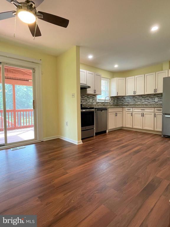 4504 Mine Rd, Fredericksburg, VA 22408 - kitchen with stainless steel appliances, decorative backsplash, under cabinet range hood, a ceiling fan, and white cabinetry