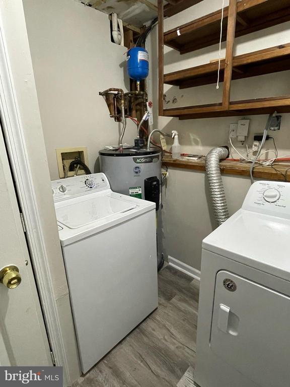 4504 Mine Rd, Fredericksburg, VA 22408 - laundry room with washing machine and dryer, electric water heater, wood finished floors, and baseboards