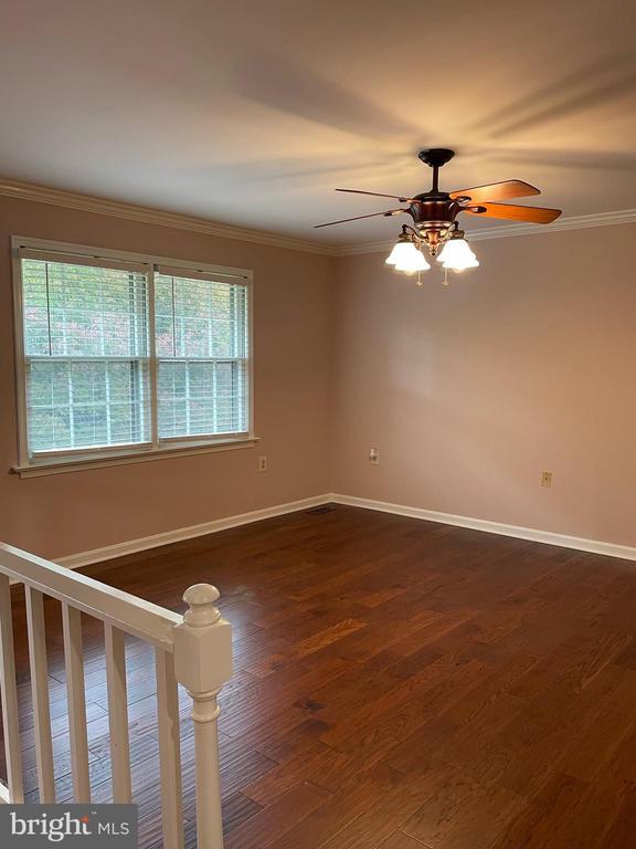 4504 Mine Rd, Fredericksburg, VA 22408 - unfurnished room featuring dark wood-type flooring, a ceiling fan, crown molding, and baseboards