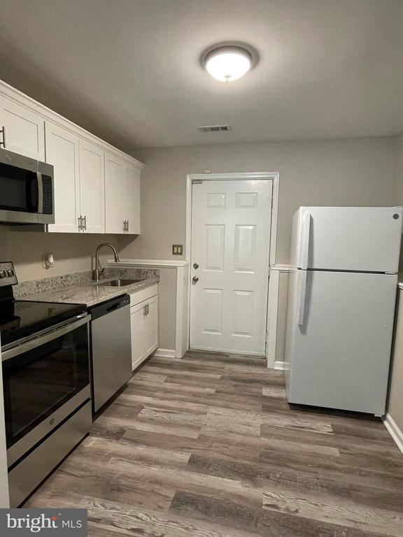 4504 Mine Rd, Fredericksburg, VA 22408 - kitchen featuring appliances with stainless steel finishes, a sink, white cabinets, and wood finished floors