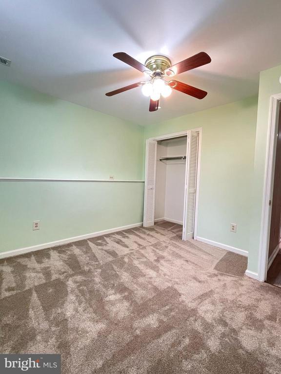 4504 Mine Rd, Fredericksburg, VA 22408 - unfurnished bedroom with carpet flooring, a closet, baseboards, and a ceiling fan