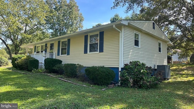 view of property exterior with a yard, central AC, and covered porch