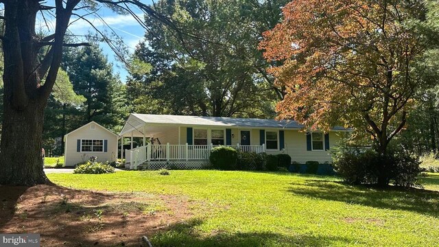 ranch-style home featuring a front lawn and covered porch