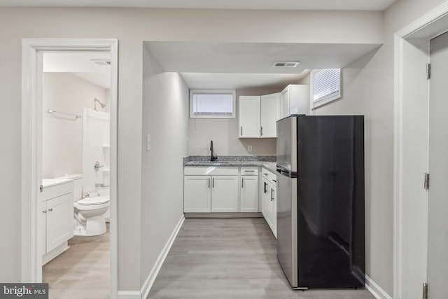 2215 Hoover Rd W, Haywood, VA 22722 - kitchen with freestanding refrigerator, white cabinets, light wood-style floors, and baseboards