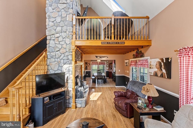 living area featuring baseboards, wood finished floors, and high vaulted ceiling
